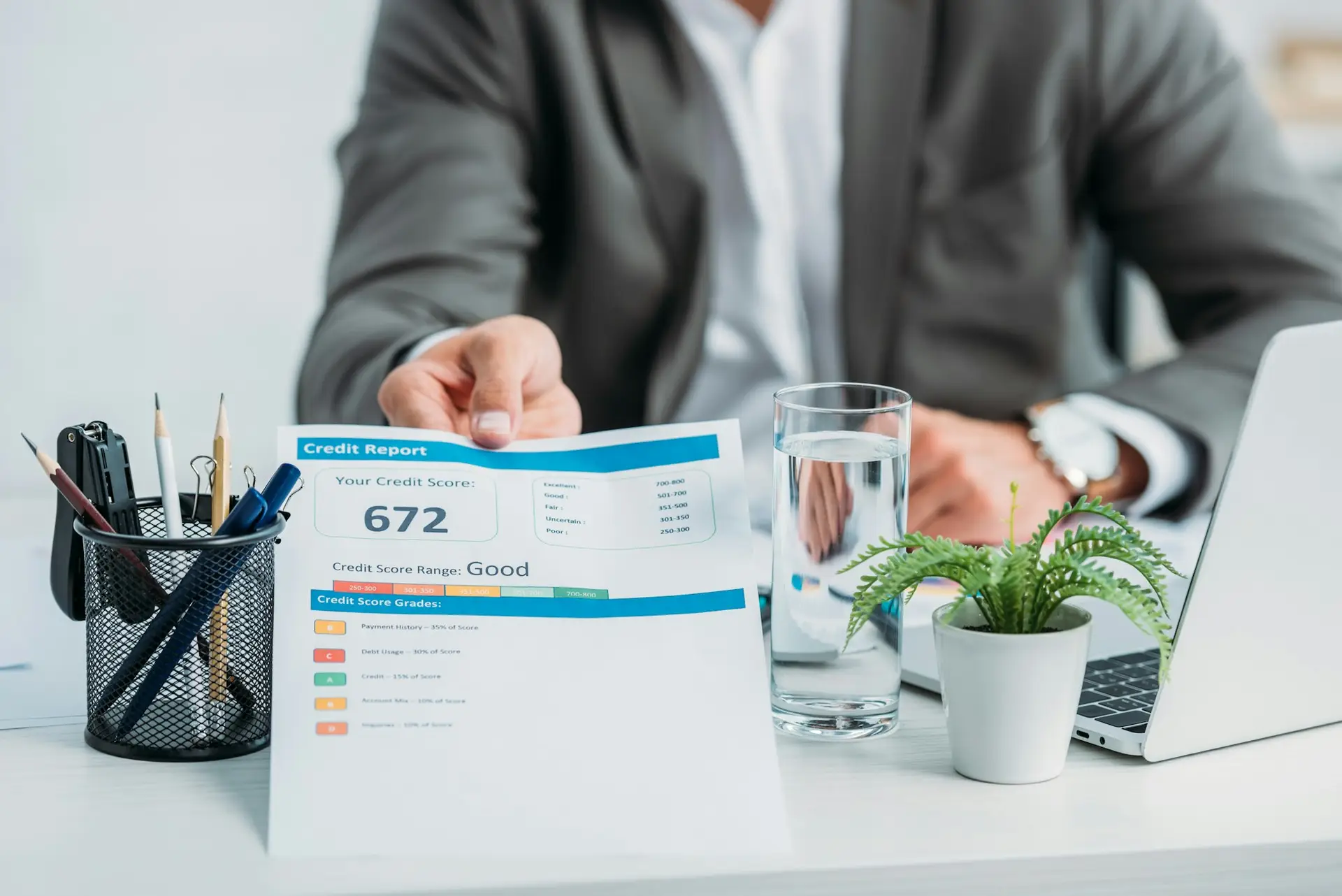 cropped view of man in formal wear holding credit report